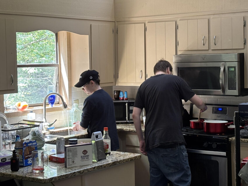 two men in a kitchen facing away